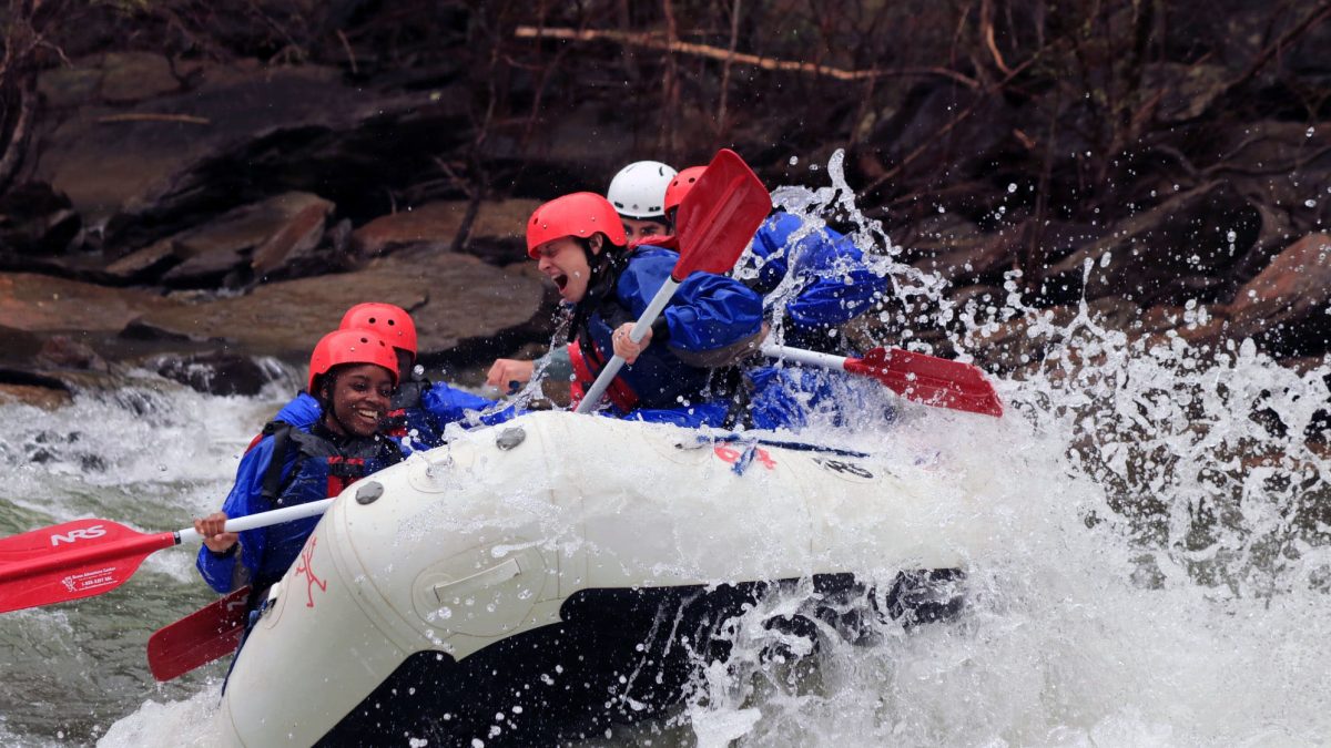 Rafters wearing splash gear in a white raft at double trouble on the Ocoee River